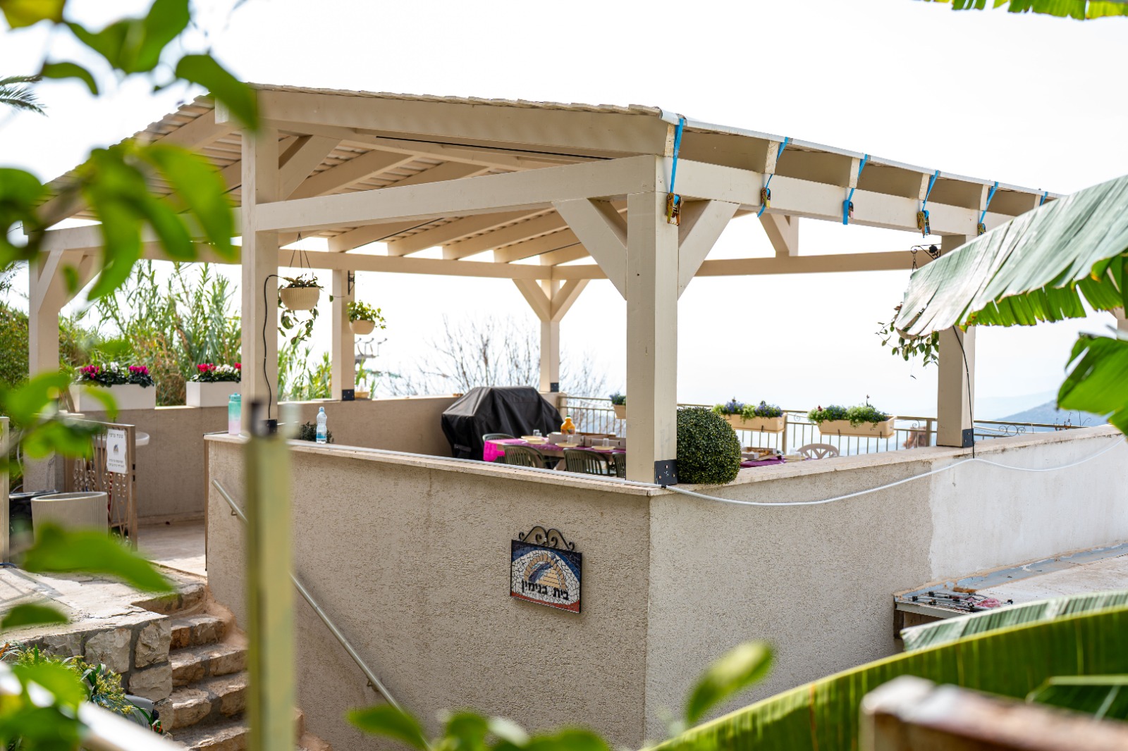 The Beit Binyamin balcony and pergola in Tzfat, with its mosaic sign